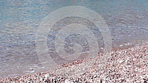 Marble pebble beach in Montenegro. Clear waves on cleanest beach of sea stones