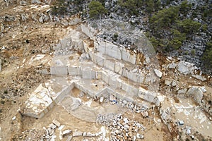 Marble quarry ledges. Terraces of cutted stone material. Aerial view