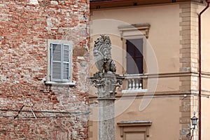 A marble replica of a florentine lion at the top of the Marzocco column in Piazza Savonarola, Montepulciano, Tuscany, Italy