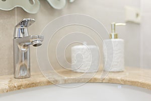 Marble sink, chrome faucet and bathroom accessories. Modern bathroom design