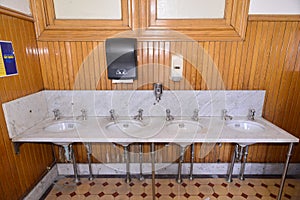 Marble sinks and wood paneling in a public restroom