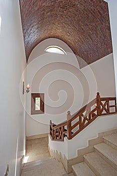 Marble staircase in luxury villa home with wooden bannister