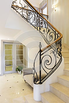 Marble stairs with handrail in bright interior