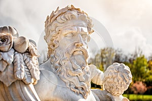 Marble statue of greek god with cornucopia in his hands.