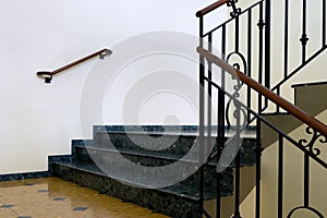 Marble steps with a handrail in the hallway