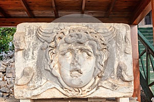 Marble tablet with ancient stone carving of Medusa Head. photo