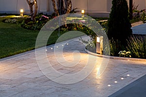 Marble tile playground in the backyard of flowerbeds and lawn with ground lantern. photo