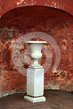 Marble vase on backdrop of defaced ancient wall