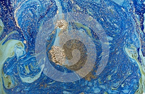 Marbled blue abstract background with golden sequins. Liquid marble ink pattern.