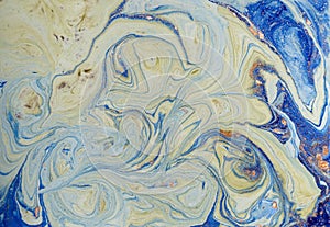 Marbled blue abstract background with golden sequins. Liquid marble ink pattern.