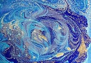 Marbled blue abstract background with golden sequins. Liquid marble ink pattern.