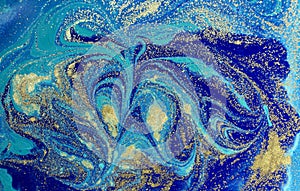 Marbled blue abstract background with golden sequins. Liquid marble ink pattern.