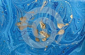 Marbled blue abstract background with golden sequins. Liquid marble ink pattern.