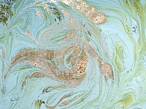 Marbled green abstract background with golden sequins. Liquid marble ink pattern.