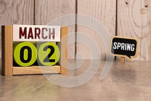 March 02 calendar date text on white wooden block with stationeries on wooden desk. Calendar date concept