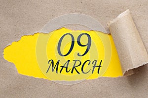 march 09. 09th day of the month, calendar date. Hole in paper with edges torn off. Yellow background is visible through