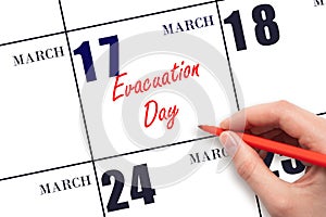 March 17. Hand writing text Evacuation Day on calendar date. Save the date.