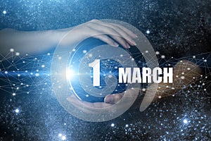 March 1st . Day 1 of month, Calendar date. Human holding in hands earth globe planet with calendar day. Elements of this image
