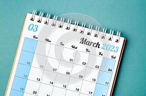 A March 2023 calendar desk for the organizer to plan and reminder isolated on blue background