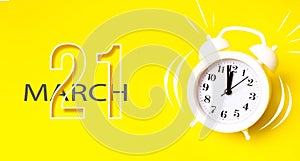 March 21st . Day 21 of month, Calendar date. White alarm clock with calendar day on yellow background. Minimalistic concept of