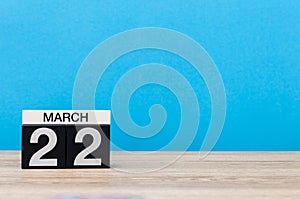 March 22nd. Day 22 of month, calendar on table with blue background. Spring time, empty space for text