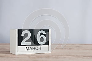March 26th. Day 26 of month, wooden calendar on light background. Spring time, empty space for text