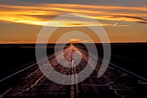 MARCH 8, 2017, NEBRASKA - Sunset over Rural Farm Country Road with pickup truck driving by row of powerlines