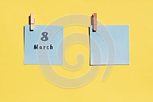 March 8st. Day of 8 month, calendar date. Two blue sheets for writing on a yellow background. Top view, copy space. Spring month,