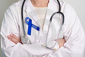 March Colorectal Cancer Awareness month, doctor with dark Blue Ribbon for supporting people living and illness. Healthcare, hope