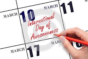 March 10. Hand writing text International Day of Awesomeness on calendar date. Save the date. photo