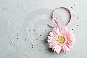 8 March, International Women`s Day. Figure eight of pink ribbon with beautiful gerbera on gray background