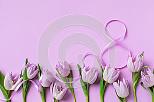 8 March. International Women's Day greeting card. Heap of fresh beautiful lilac tulip flowers on pastel table