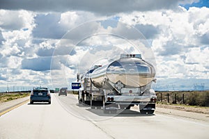 March 15 2018 Lost Hills / CA / USA - Tanker truck driving on interstate I5, the road being reflected in its shiny cistern