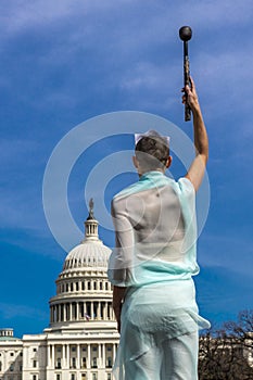 MARCH 24, 2018 - Washington DC, Female poses like Statue of Liberty in front of US Capitol,. Democracy, torch