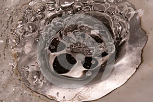 Marcro photography as water drains into the sink