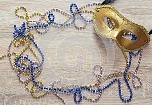 Mardi Gras background with golden mask, beads and copy space.