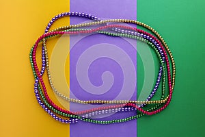 Mardi Gras beads background with place for text. Top view