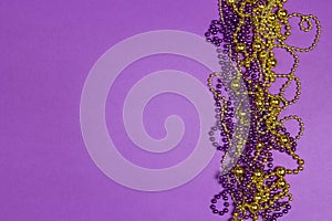 Mardi Gras beads on purple background