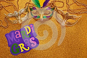 Mardi gras or carnival mask with beads on gold glowing background. Venetian mask.