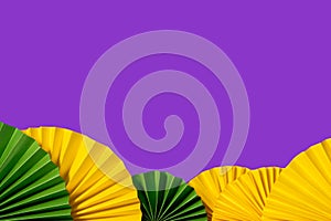 Mardi gras festive traditional color background. Abstract background yellow, green, purple. Paper fans Mardi gras