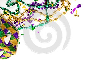 A Mardi gras mask and beads on a white background with copy space