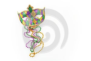 Mardi gras mask and colorful beads on white background
