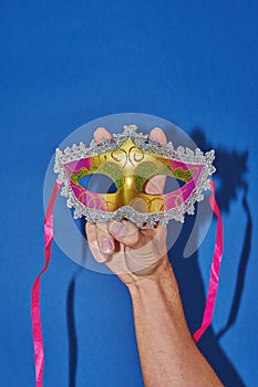 Mardi Gras masquerade mask on blue with confetti, copy space