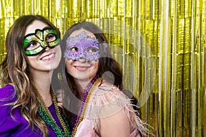Mardi gras party. Women with a carnival mask and beads on the golden festive background