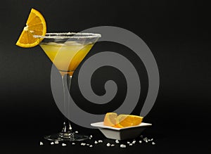 Margarita cocktail with slices of orange on the black background.