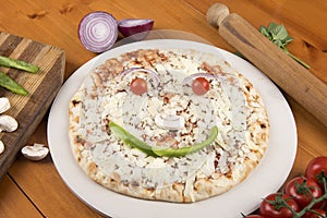 Margarita pizza with raw ingredients making a smile