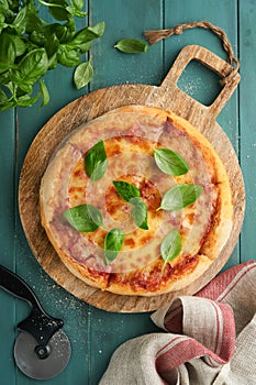 Margarita pizza. Traditional neapolitan margarita pizza and cooking ingredients tomatoes basil on wooden table backgrounds