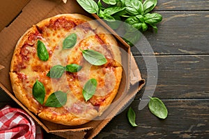 Margarita pizza. Traditional neapolitan margarita pizza and cooking ingredients tomatoes basil on wooden table backgrounds.