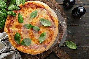 Margarita pizza. Traditional neapolitan margarita pizza and cooking ingredients tomatoes basil on wooden table backgrounds.