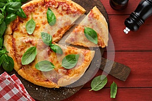 Margarita pizza. Traditional neapolitan margarita pizza and cooking ingredients tomatoes basil on wooden table backgrounds.